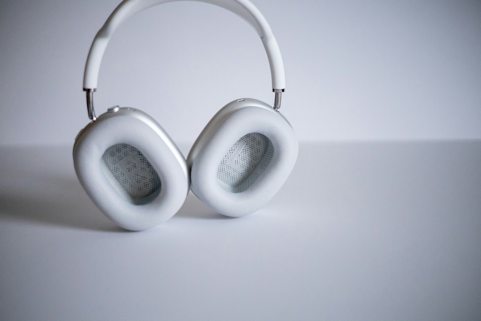 white and silver headphones on white table